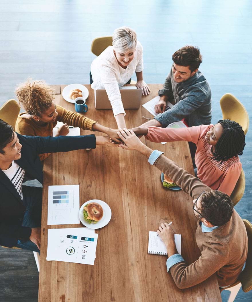Team collaborating around a table, symbolizing over two decades of innovative IT solutions. Emphasizing AI, machine learning, data analytics, CMMI Level 5 development, ISO standards, PMBOK-aligned project management, and digital service excellence.